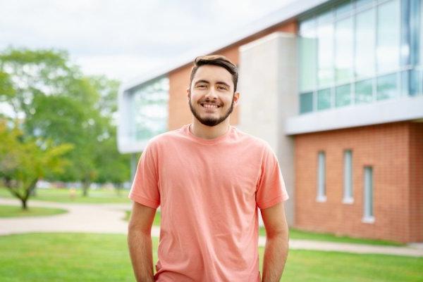 传播与传媒专业，《利记sbo》主编, Matthew Breault, stands on campus, smiling at camera.